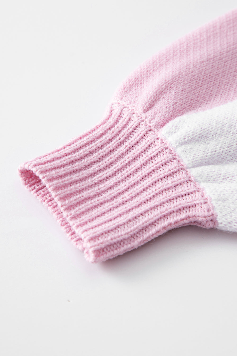 Close-up of the cuff of a pink checkered bishop sleeve sweater, showcasing its soft knit texture and elegant design.